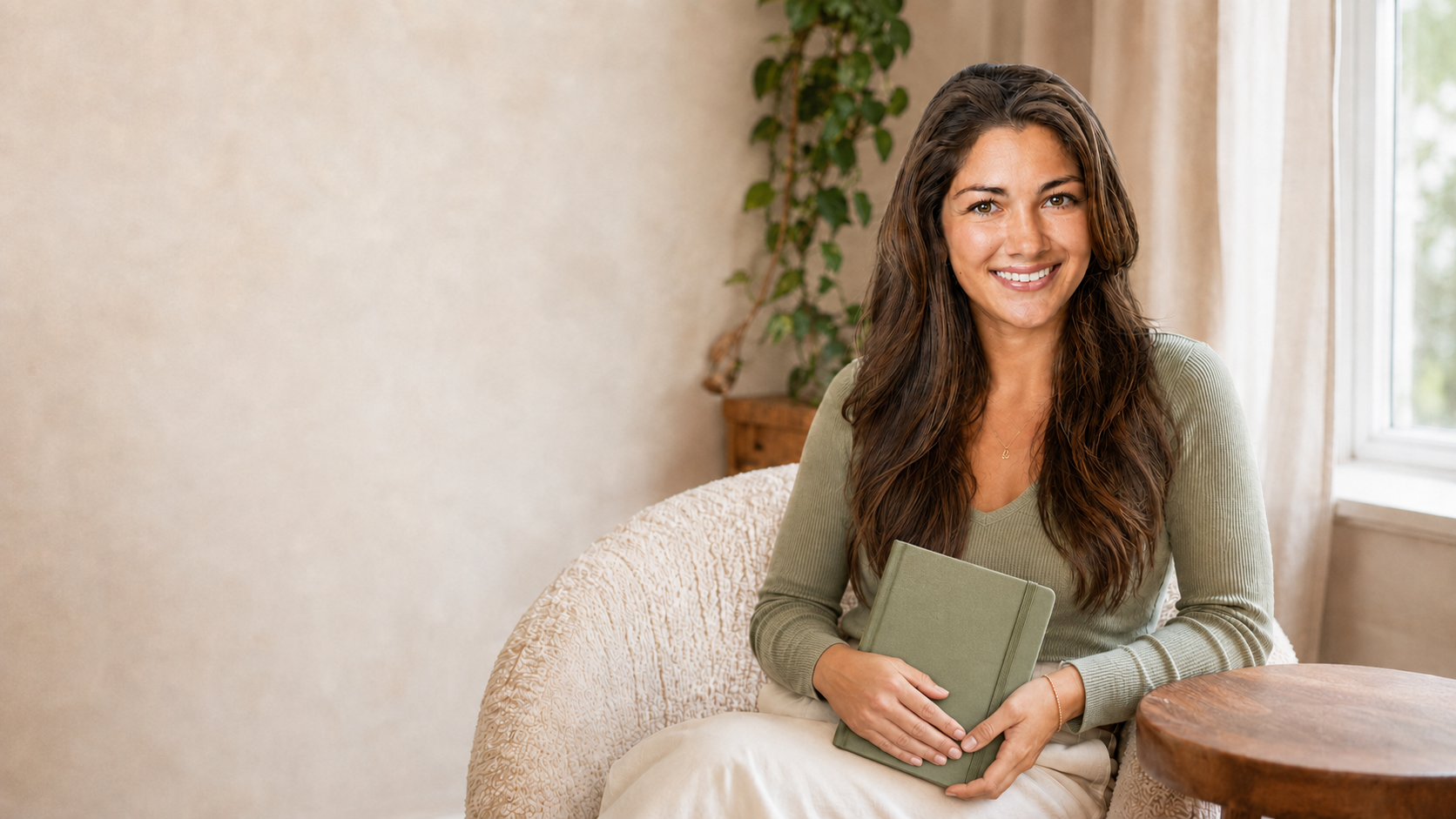 Erin Spittal seated in a cream chair holding a journal